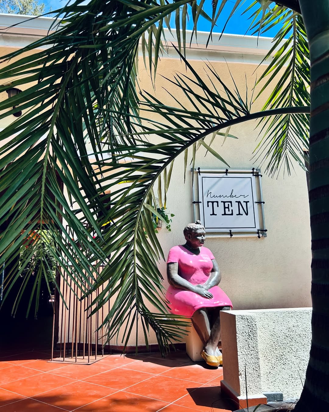 Ontbijten lunchen Number 10 Curacao – ingang met standbeeld en palmbomen